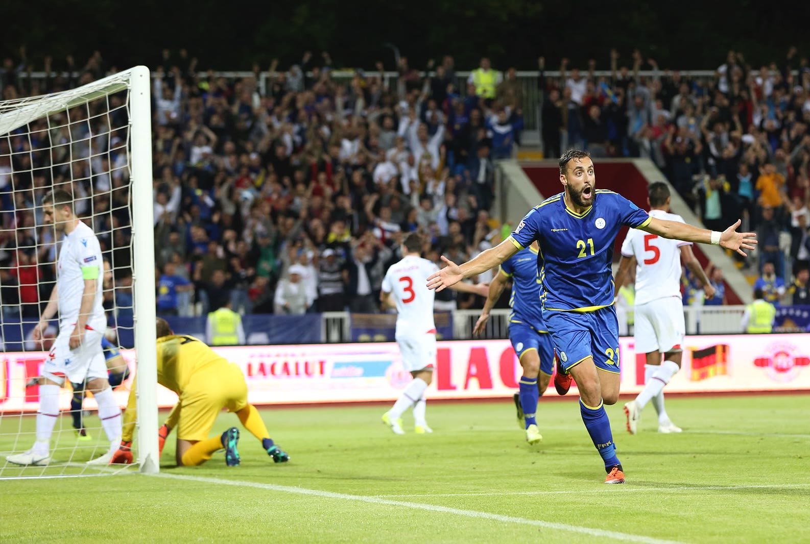 Atdhe Nuhiu jubelt mit ausgebreiteten Armen nach einem Tor für den Kosovo, im Hintergrund jubeln die Fans